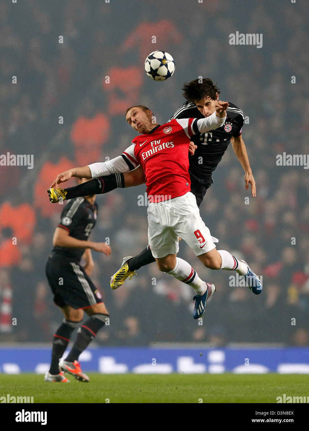 Feb. 19, 2013 - London, United Kingdom - Arsenal's Lukas Podolski tussles with Munich's Javi Martinez..Arsenal v Bayern Munich - Champions League Second Round, First Leg- Emirates Stadium, London- 19/02/13 - Picture David Klein/Sportimage Stock Photo