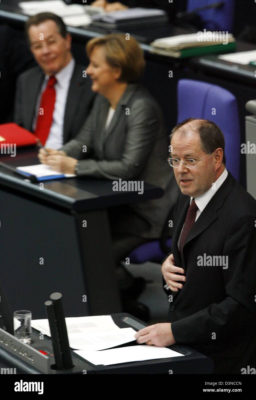 Federal Minister of Finance Peer Steinbrueck (R) comments on the governmental budget draft in the Bundestag in Berlin, Germany, Tuesday, 28 March 2006. Behind him on the government bench are Vice-Chancellor and Minister of Labour Franz Muentefering (L) and Federal Chancellor Angela Merkel (C). The parliament debates the budget for 2006 in the first reading. Photo: Steffen Kugler Stock Photo