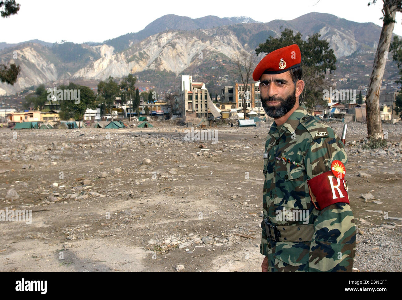 A Pakistani soldier stand nearby the ruins of a destroyed hsopital in Muzaffarabad in Pakistan, Monday, 30 January 2006. Millions of people suffered in the aftermath of an earthquake which struck in October 2005 hitting the province of Kashmir. Photo: Wolfgang Langenstrassen Stock Photo