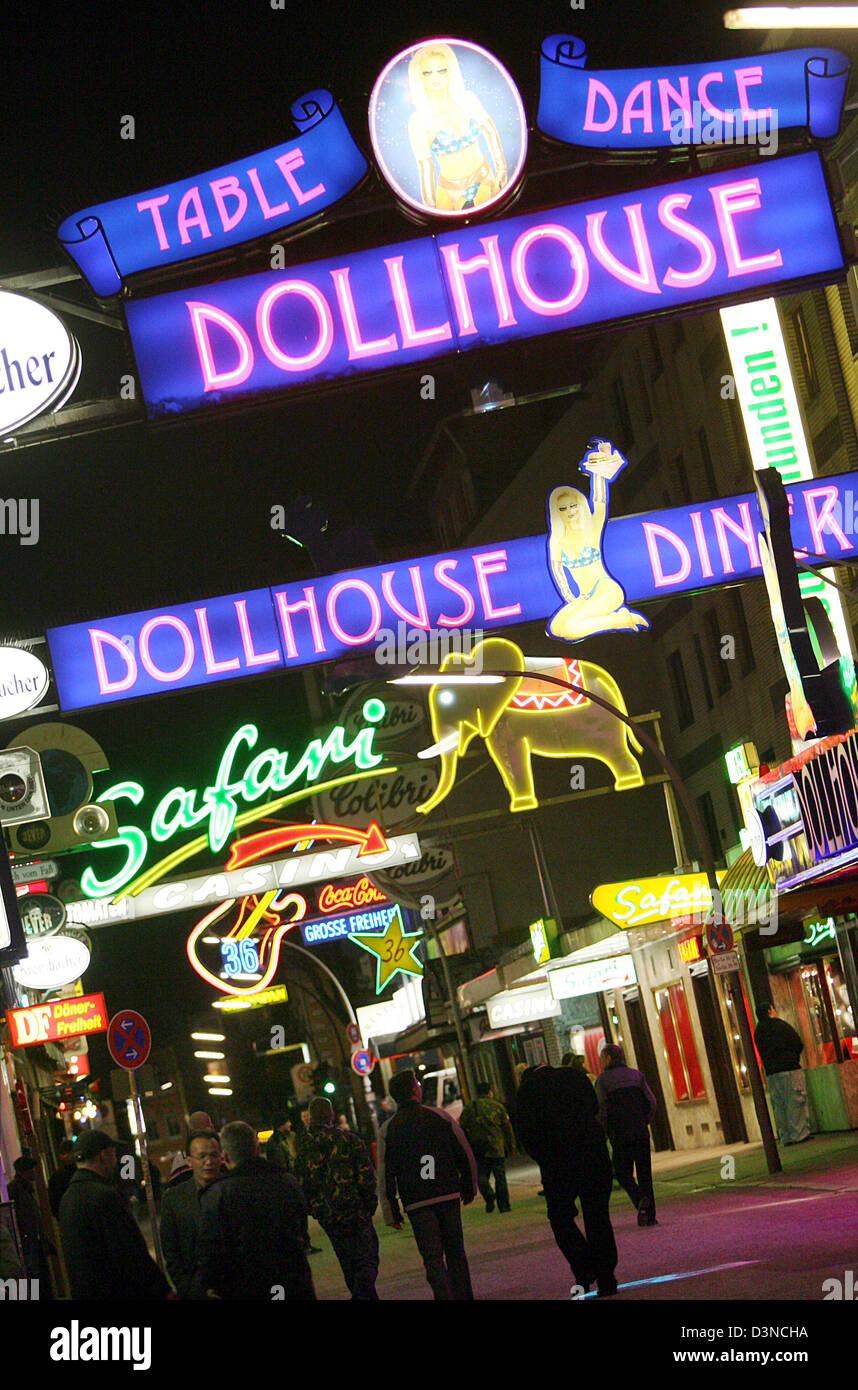 Pedestrians walk underneath colourful neon-lit signs advertising adult entertainment clubs on the famous Reeperbahn amusement street in Hamburg, Germany, Tuesday night, 28 March 2006. The famous Reeperbahn is considered the longest amusement street in the world. Photo: Kay Nietfeld Stock Photo