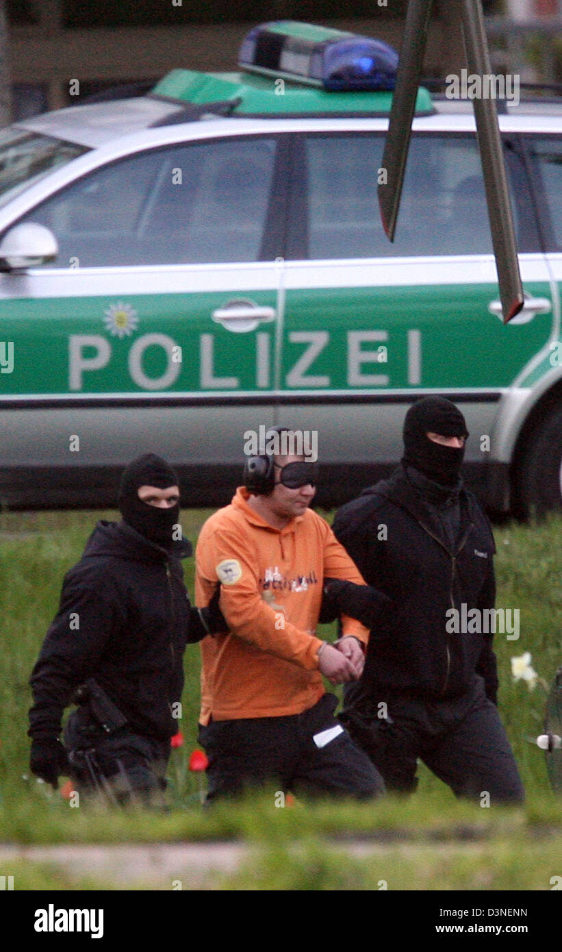 Police officers lead one of two suspects to the helicopter after a writ of habeas corpus at the Federal Court of Justice (BGH) in Karlsruhe, Germany, 21 April 2006. The man is investigated for murder attempt on a German-Ethiopian in Potsdam, Germany allegedly having smashed and perilously injured him. Photo: Uli Deck Stock Photo