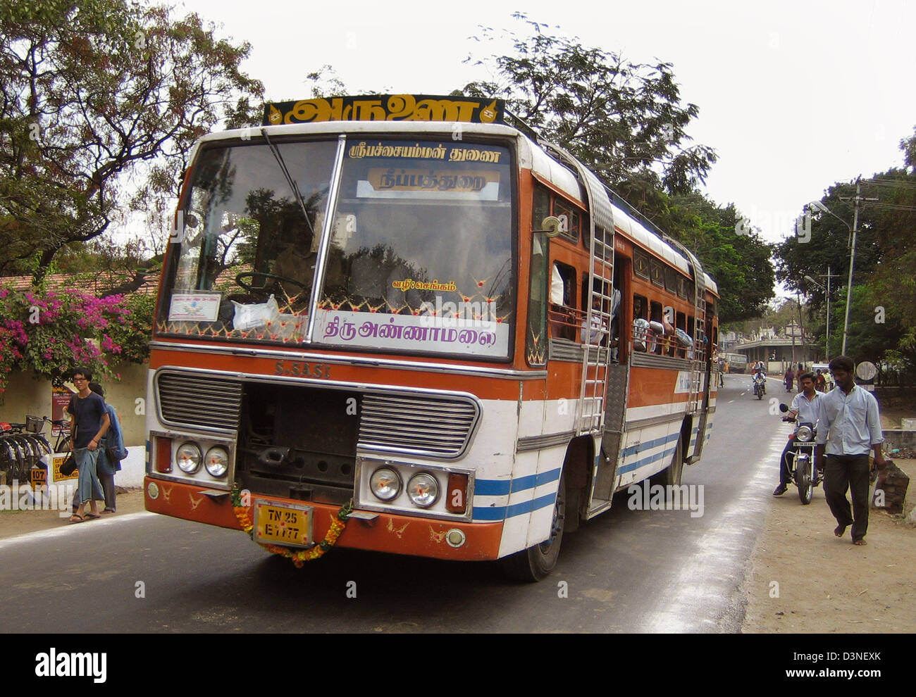 A painted bus drives on a street in Tiruvannamalai located in the ...