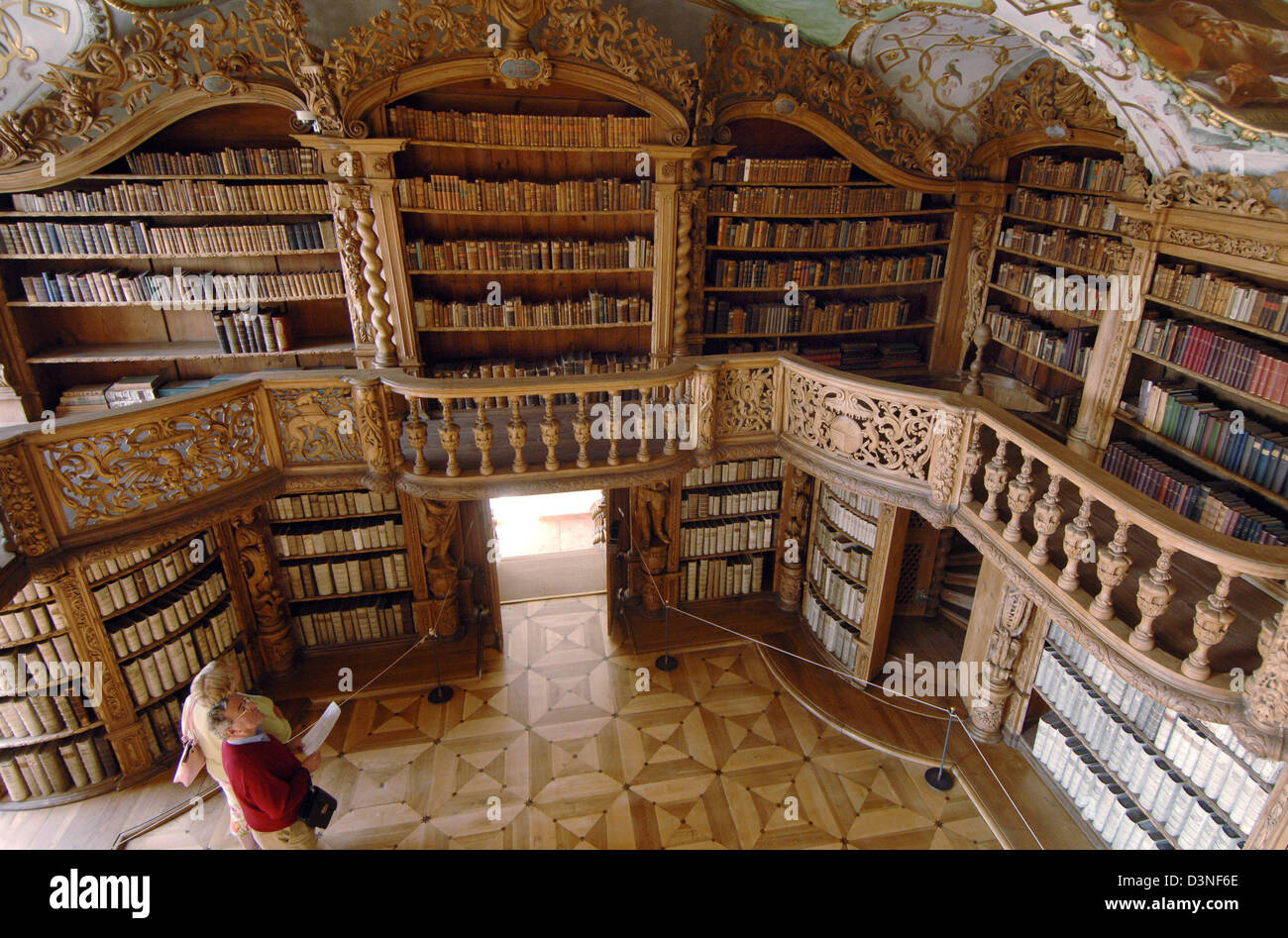 The picture shows the impressive interior of the monastic library in Waldsassen, Germany, 24 April 2006. Accomplished in 1726 the monastic library stuffed with more than 2,000 volumes of theologic papers marks the transient of style from the High Baroque to Rococo. The ten livesize wooden figures graved by sculptor Karl Stilp (1668 - 1735) carry the gallery spanning around the hall Stock Photo