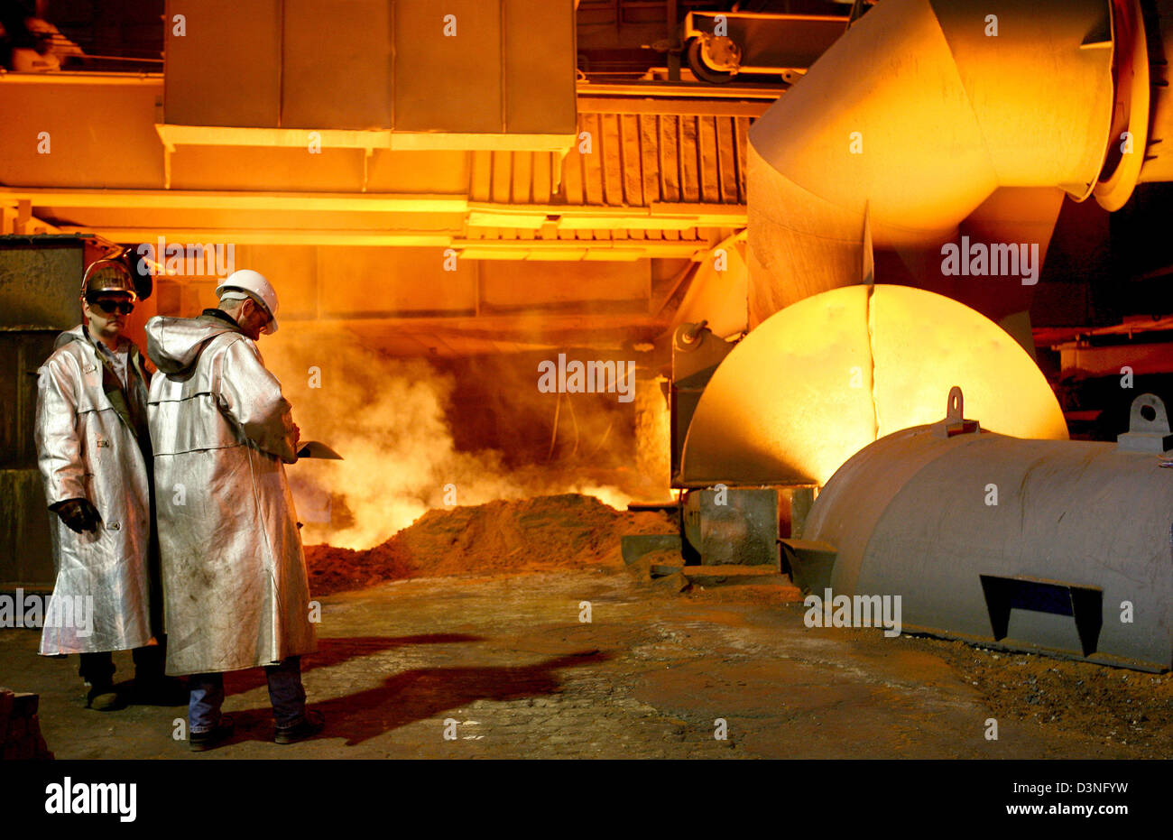 Employees of the German steel giant ThyssenKrupp AG observe steel