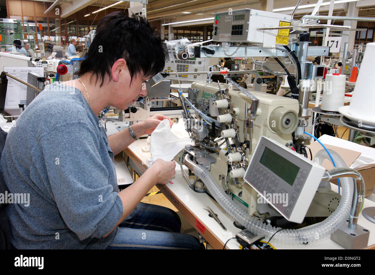 An employee of 'mey bodywear' sews together pieces of fabric for