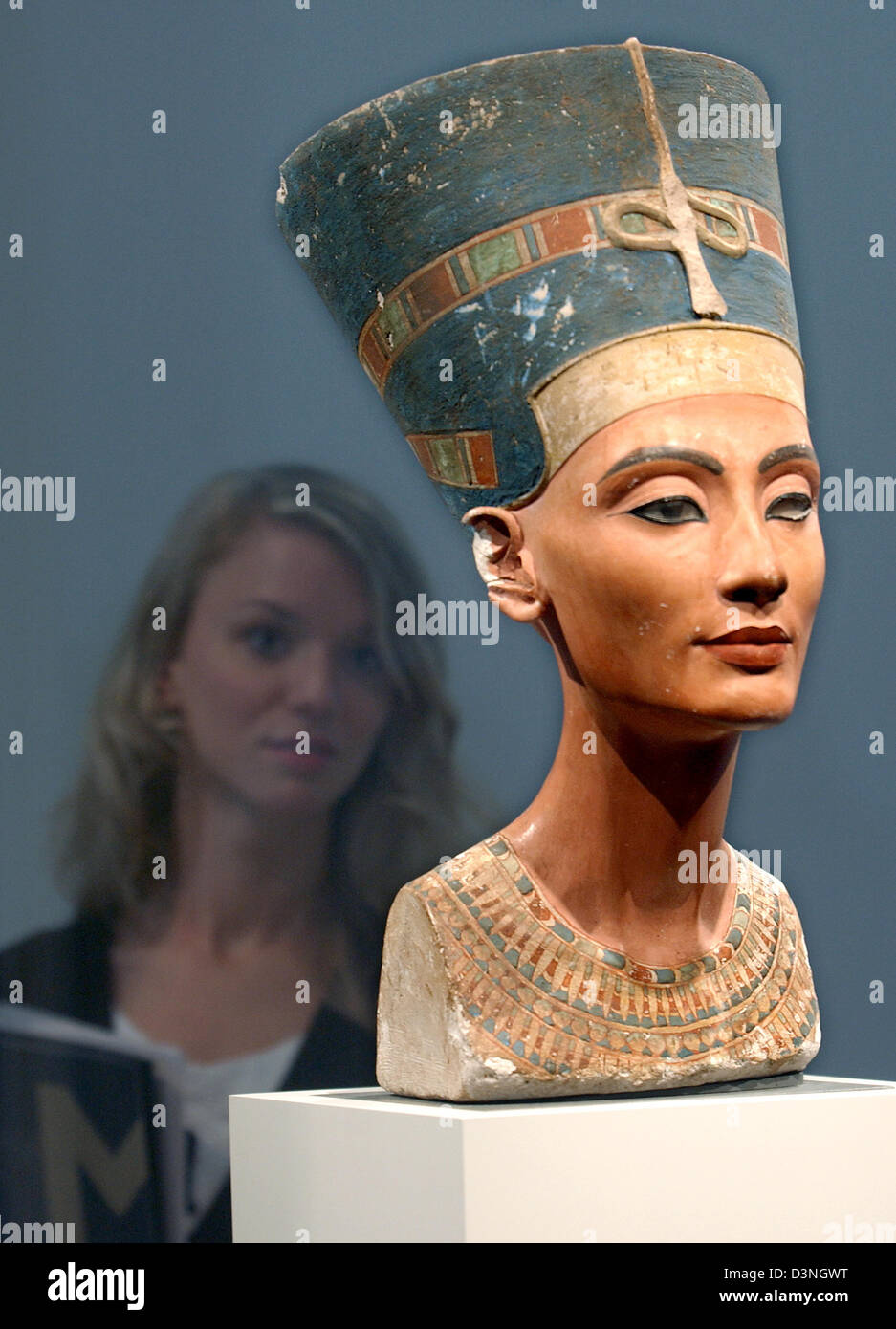 (dpa file) - A visitor examines the bust of the ancient Egyptian queen Nefertiti in Altes Museum in Berlin, Germany, 12 August 2005. Berlin will continue to be its home after a spokesperson of the Stiftung Preußischer Kulturbesitz declared on Thursday, 11 May 2006, it would not go to the opening of the 'Egypt's Sunken Treasures' exhibition. Photo: Stephanie Pilick Stock Photo