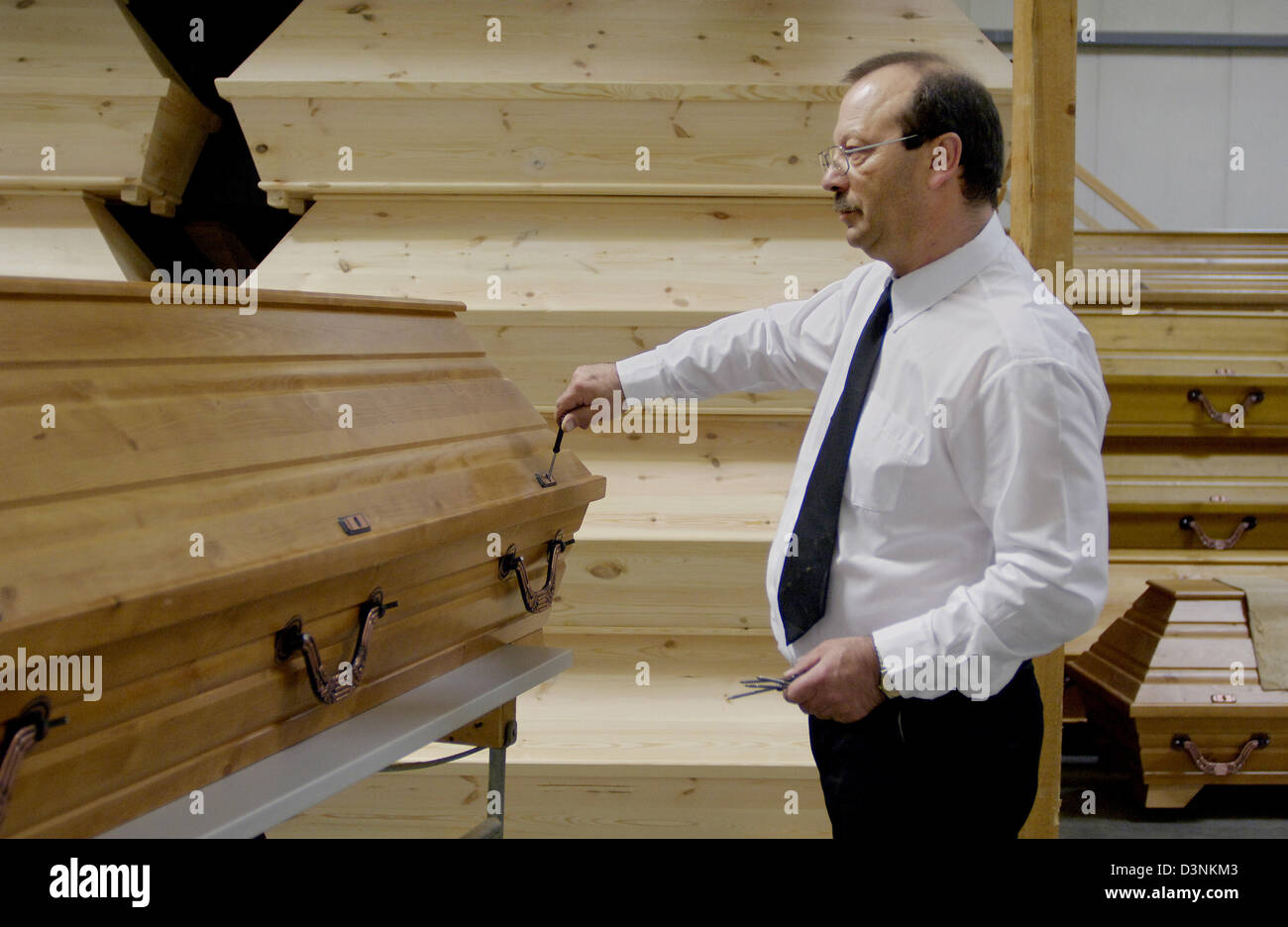 An Employee of the funeral undertaker Karl Schumacher closes a coffin