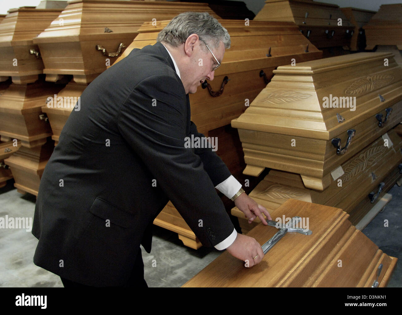 Funeral undertaker Karl Schumacher inspects a coffin in his store room