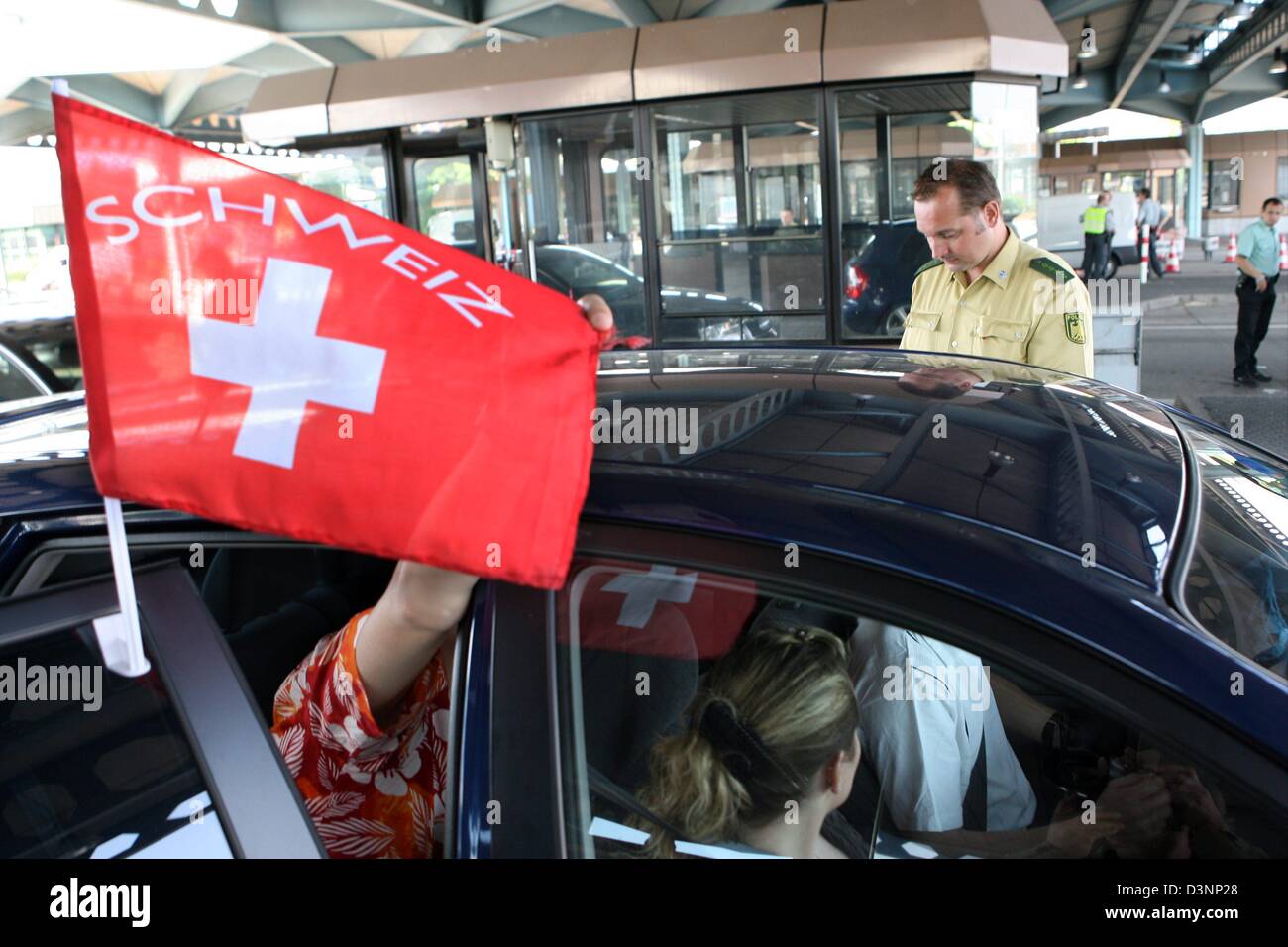 A German border control officer checks the documents of Swiss soccer fans at the German-Swiss border control station Basel-Weil am Rhein, Germany, Tuesday, 13 June 2006. Police and border control intesified the controls at the borders of Switzerland and France due to the FIFA World Cup Group G match France vs Switzerland today in Stuttgart, Germany. Photo: Rolf Haid Stock Photo