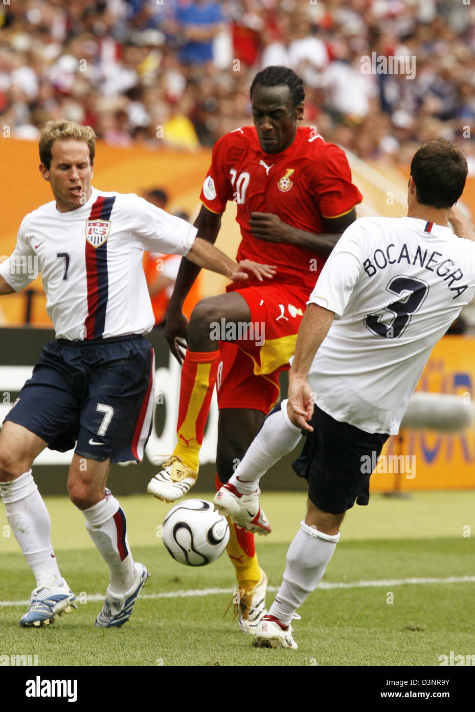 Stephen Appiah of Ghana (C) vies for the ball with Eddie Lewis (L) and Carlos Bocanegra (R) of USA during the group E preliminary round match of the 2006 FIFA World Cup between Ghana and USA in Nuremberg, Germany, Thursday 22 June 2006. DPA/DANIEL KARMANN +++ Mobile Services OUT +++ Please also refer to FIFA's Terms and Conditions. Stock Photo