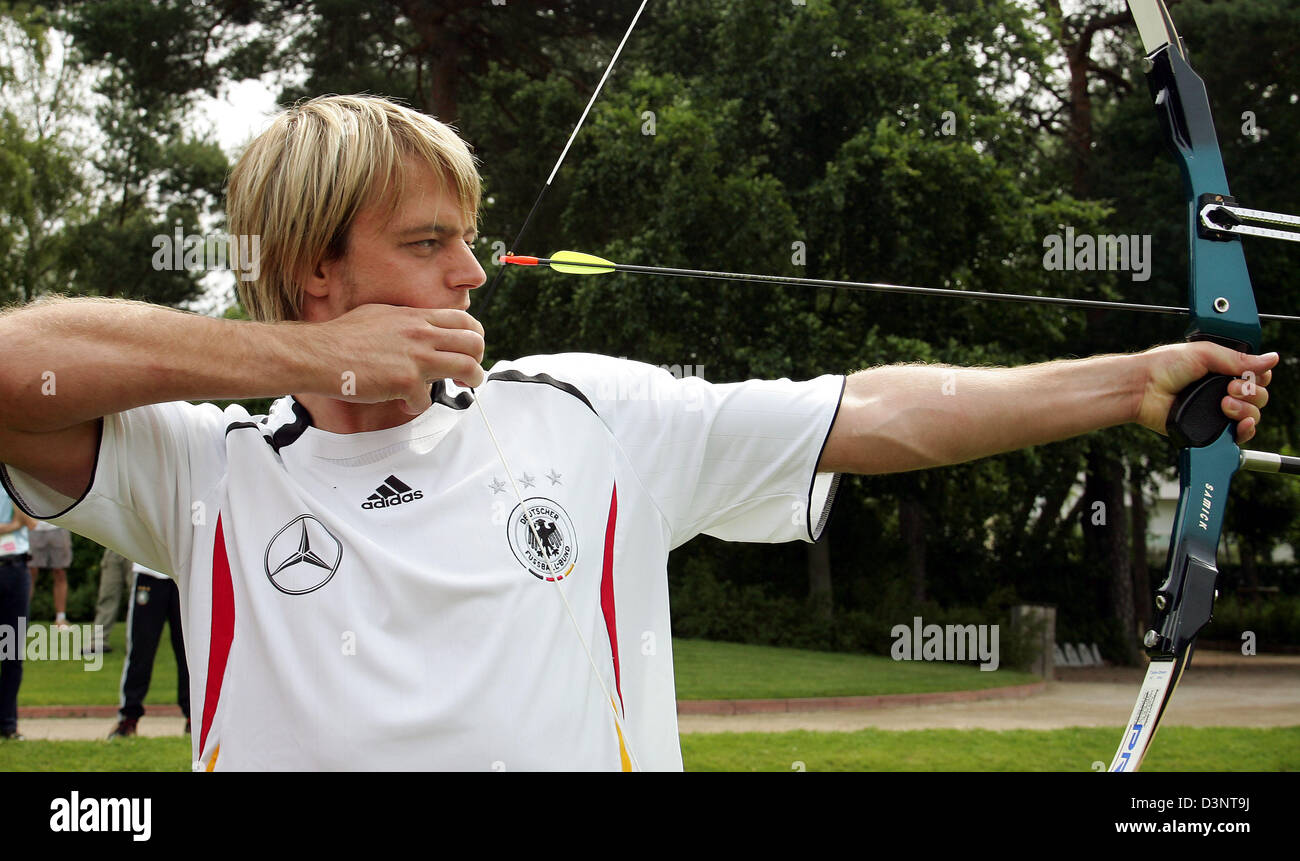 German national soccer reserve goalkeeper Timo Hildebrand aims with a bow at the facilities of Tennis Club Blau-Weiss Grunewald in Berlin, Germany, Wednesday, 28 June 2006. Under the supervision of the German national archery team coach the players of the German national soccer team got an archery introduction. Photo: Markus Gillar Stock Photo