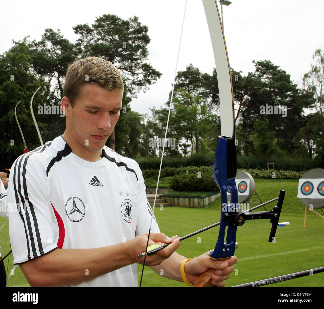 German national soccer player Lukas Podolski prepares to shoot an arrow at the facilities of Tennis Club Blau-Weiss Grunewald in Berlin, Germany, Wednesday, 28 June 2006. Under the supervision of the German national archery team coach the players of the German national soccer team got an archery introduction. Photo: Markus Gillar Stock Photo