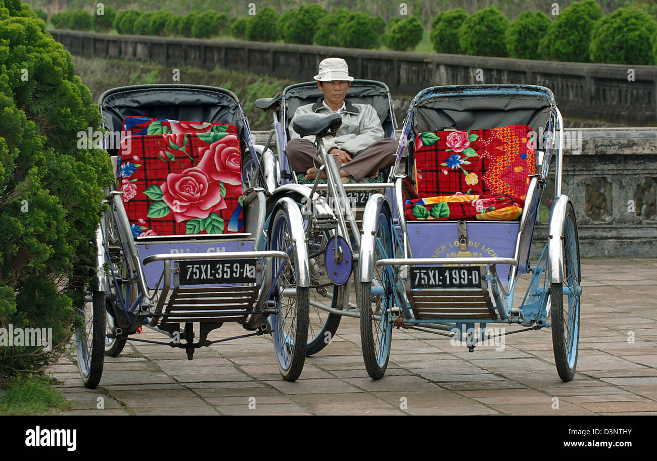 Rickshaw rider waits for clientele in front of the imperial city in Hue ...