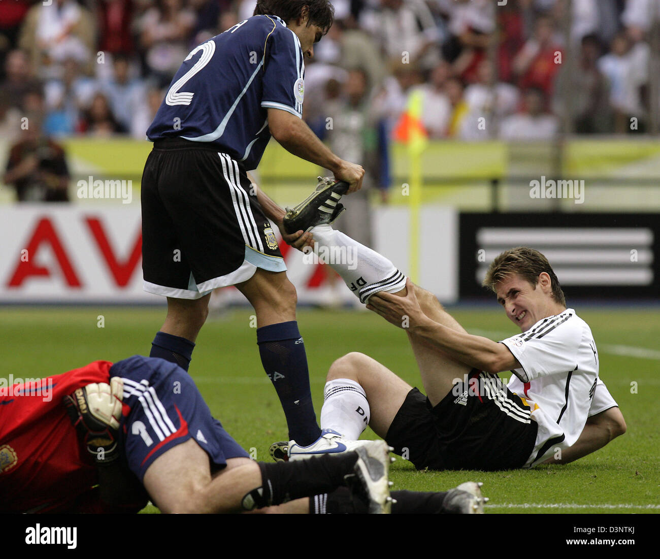 Miroslav Klose of Germany (R) is helped by Roberto Ayala (L) of Argentina during the quarter final of the 2006 FIFA World Cup between Germany and Argentina in the Olympic stadium in Berlin, Germany, Friday, 30 June 2006. In the foreground injured Argentinian goalkeeper Roberto Abbondanzieri. Photo: JENS WOLF +++ Mobile Services OUT +++ Please refer to FIFA's Terms and Conditions. Stock Photo
