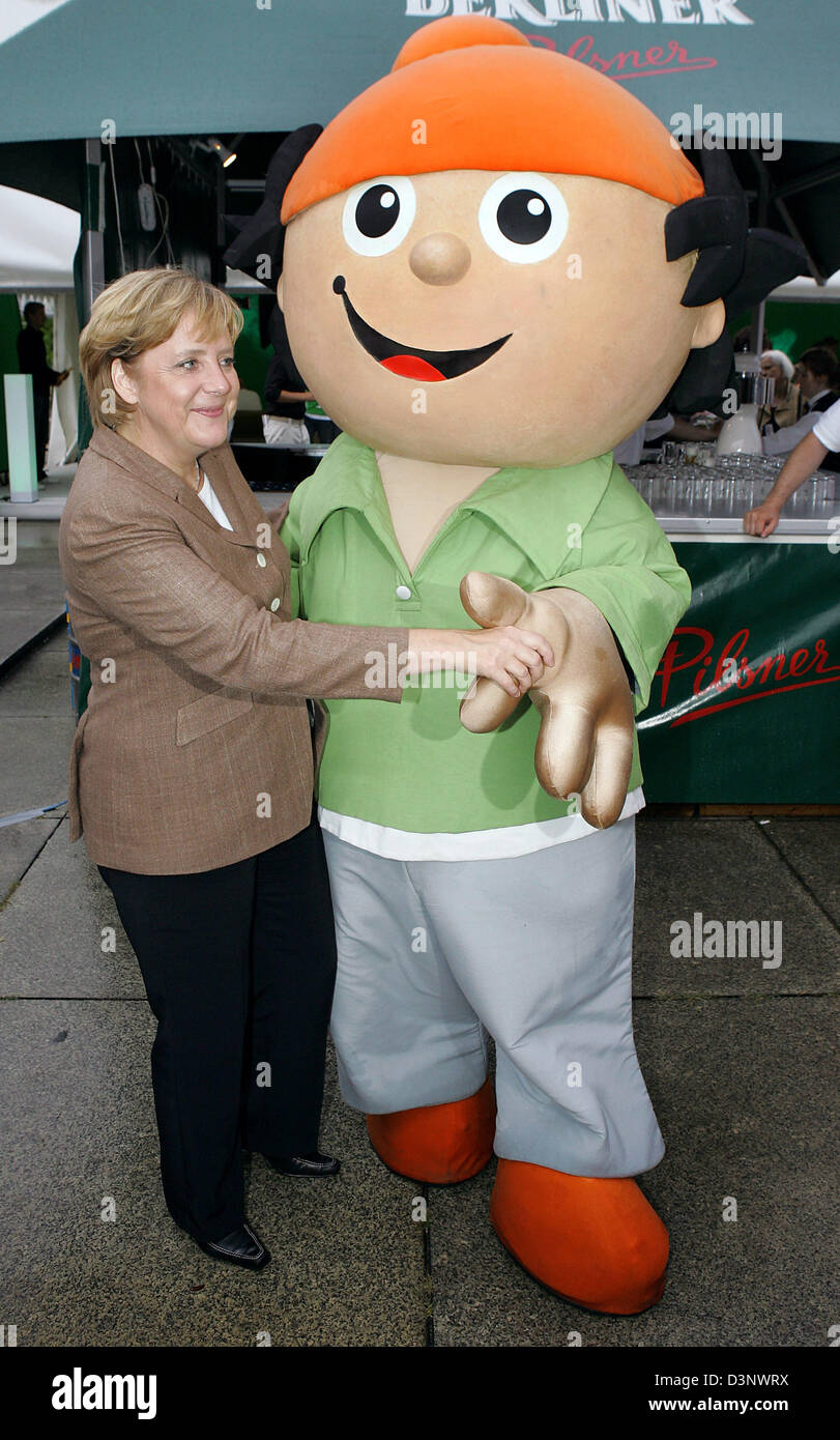 Chancellor Angela Merkel dances with a Mainzelmännchen puppet at the summermeeting of the German TV channel 'Zweites Deutsches Fernsehen' (ZDF) in Berlin, Germany, Friday, 07 July 2006. The traditional party took place near the New National Gallery in Berlin at the beginning of the parlamentary summer break. Photo: Soeren Stache Stock Photo