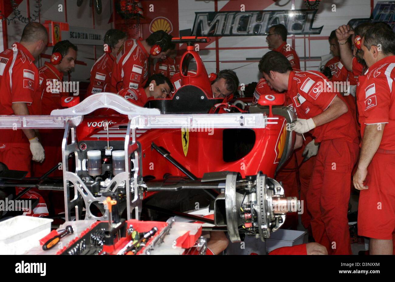 Mechanics of the Scuderia Ferrari team work on Michael Schumacher's car