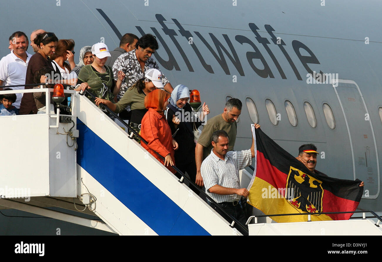 German refugees from the Lebanon wave a German flag as they get out of the Bundeswehr plane at the military part of the airport Cologne/Bonn, Germany, Thursday, 20 July 2006. It is the first of three planes with about 200 refugees each. The plane was late because of a late departure in Damaskus. Photo: Felix Heyder Stock Photo