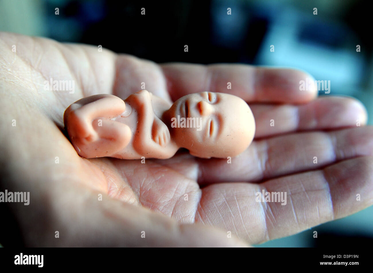 Tiny baby foetus doll held in palm of hand used by anti abortion campaigners Stock Photo