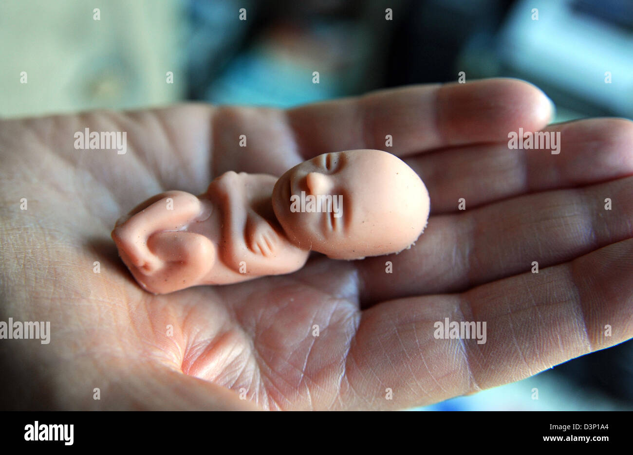Tiny baby foetus doll held in palm of hand used by anti abortion campaigners Stock Photo