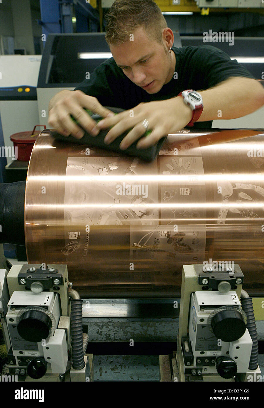 An employee at the print factory Prinovis checks the copper-plated gravure cylinder for possible flaws in Nuremberg, Germany, Tuesday 27 June 2006. Photo: Daniel Karmann Stock Photo