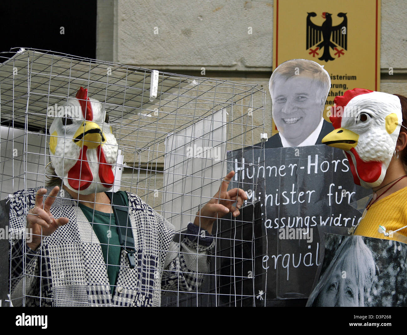 Animal rights activists with hen masks protest on laying hen cages at the German Ministry of Agriculture in Berlin, Germany, Friday, 4 August 2006. Members of animal rights organisation PETA built a symbolic wall around the ministry. From Friday on the new regulation on hen cages which are to be just slightly larger than the cage batteries. Photo: Wolfgang Kumm Stock Photo