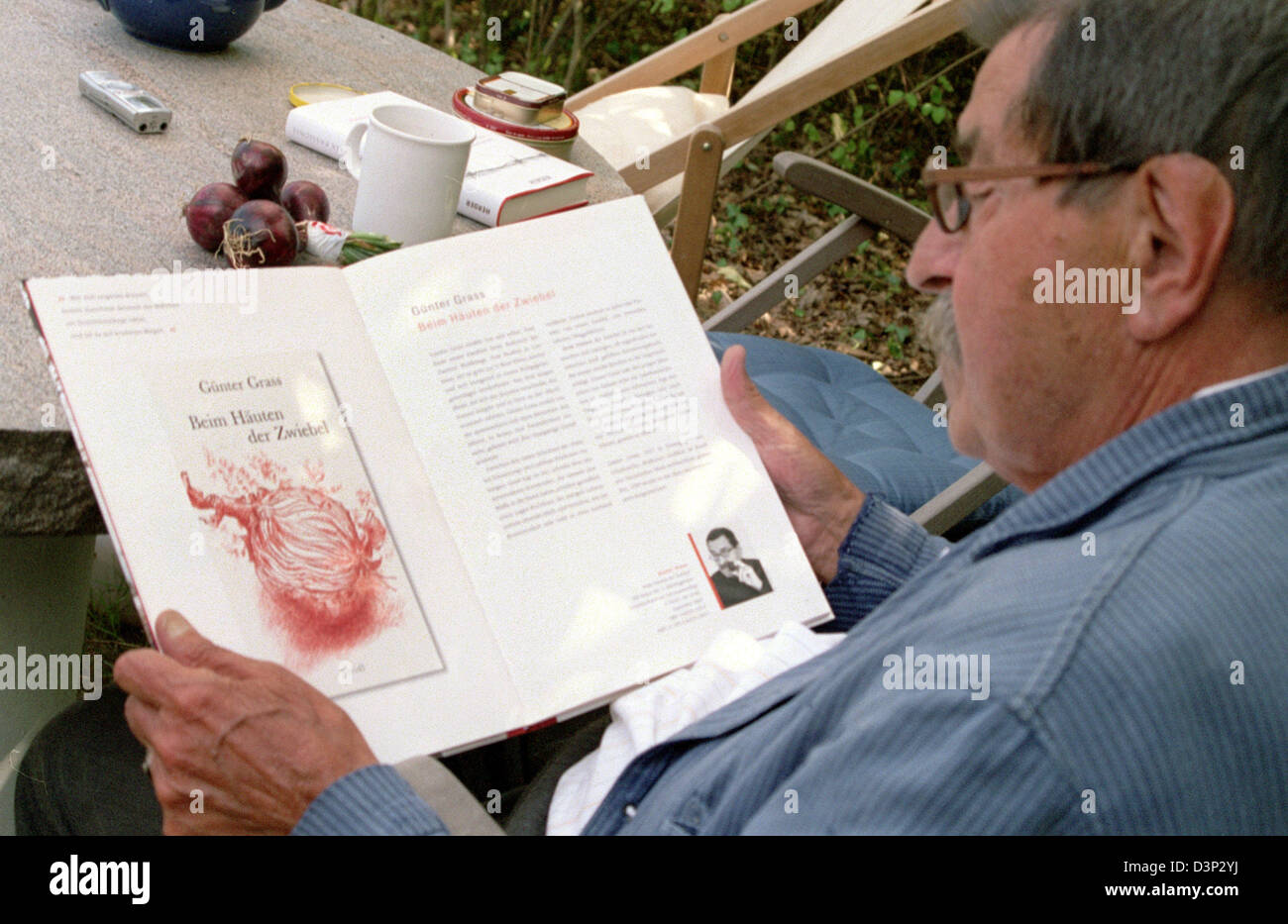 German author and Nobel literature laureate Guenter Grass skims through his autobiography 'Peeling Onions' ('Beim Haeuten der Zwiebel') due to appear in September in his holiday domicile on the island Moehn, Denmark, 5 August 2006. The confession of the 78-year-old having formed part of the Waffen SS during World War II continues to cause a controversial debate. Photo: Matthias Hoe Stock Photo