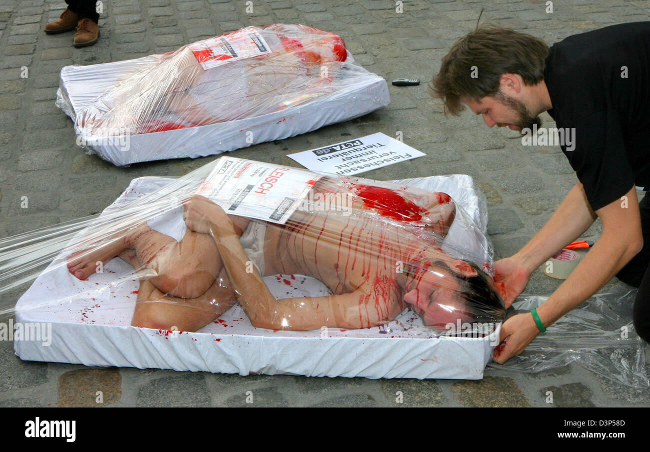 Activists of PETA, an organization fighting animal abuse world wide, are being packed in giant meat dishes in Rostock, Germany, Wednesday 06 September 2006.  PETA demonstrate for the abdication of meat and against excruciating animal husbandry. Their slogen 'put yourself in the animals' place' will lead them through further protests in Schwerin, Kiel, Hamburg, Dortmund and Essen. C Stock Photo