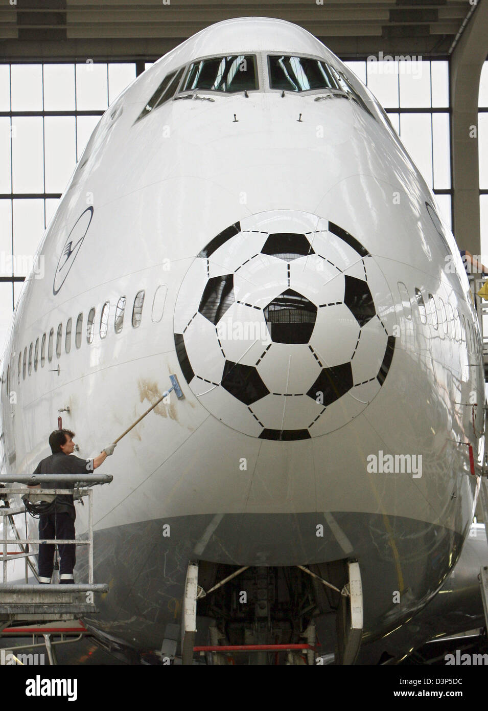 An engineers polishes the fuselage exterior of a Boeing 747 by Lufthansa at the airline's dockyard in Frankfurt, Germany, Monday 14 August 2006. Photo: Boris Roessl Stock Photo