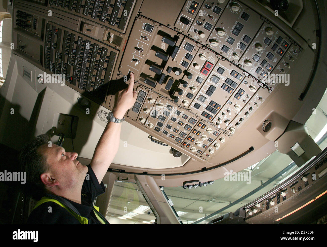 An engineer mounts a switch in the cockpit of a Boeing 747 by Lufthansa at the airline's dockyard in Frankfurt, Germany, Monday 14 August 2006. Photo: Boris Roessl Stock Photo