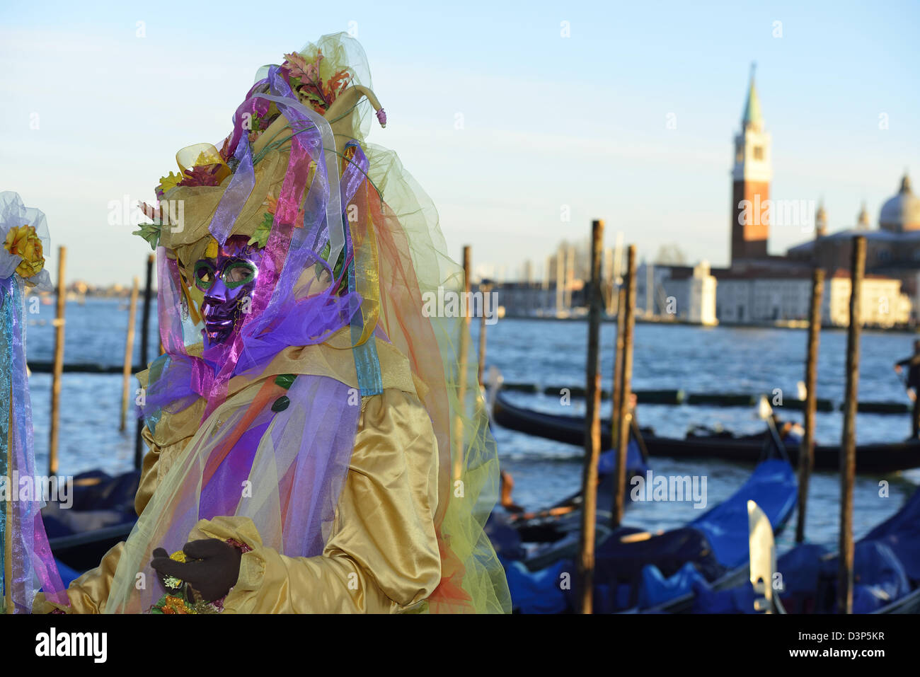 Masks during 2013 carnival with the island and church of S.Giorgio Maggiore in the background; Venice, Veneto. Italy Stock Photo