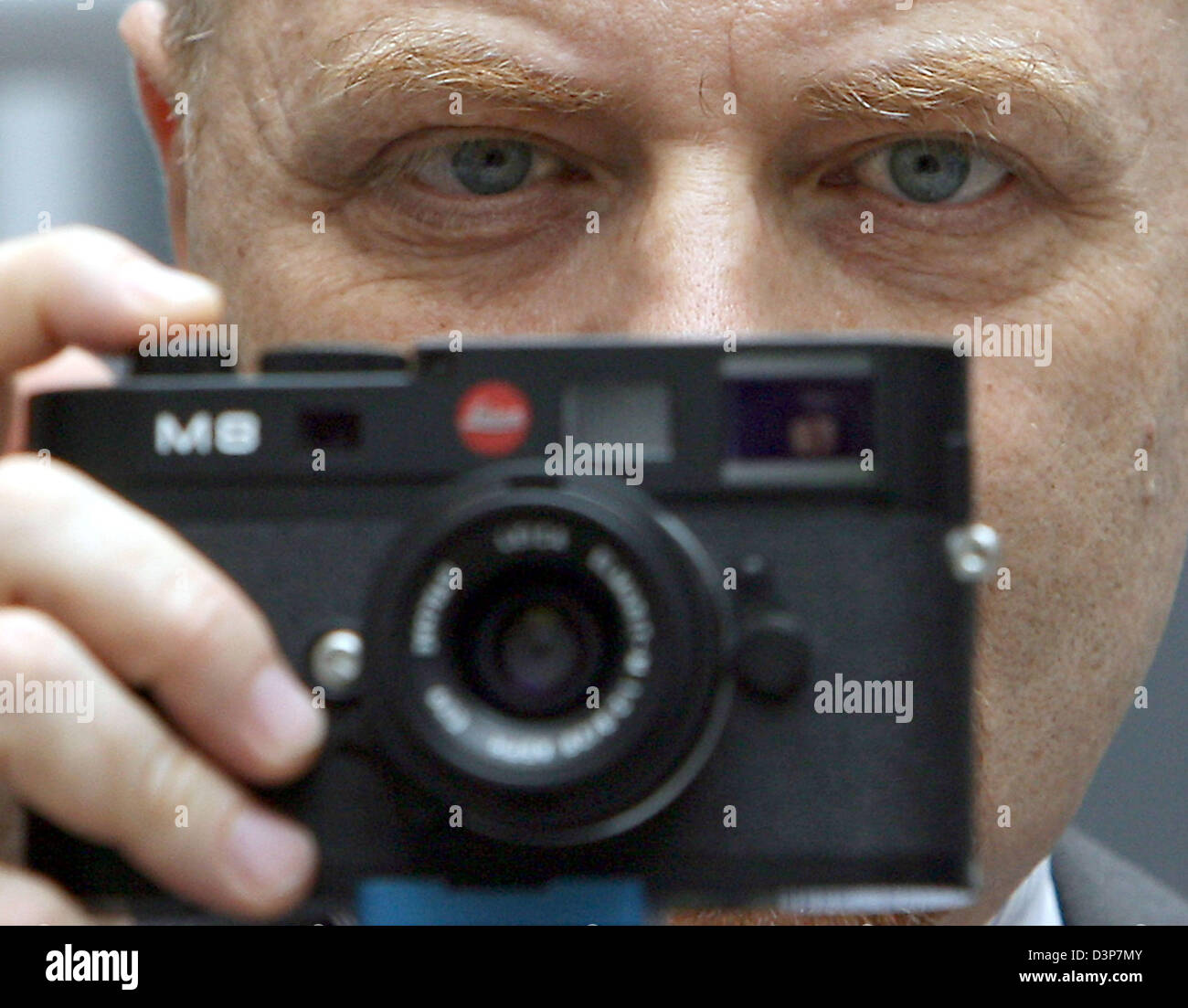 A visitor of the Photokina looks through the new digital Leica M8 in Cologne, Germany, Tuesday, 26 September 2006. The world's largest photography trade fair will take place until 01 October 2006. Photo: Oliver Berg Stock Photo