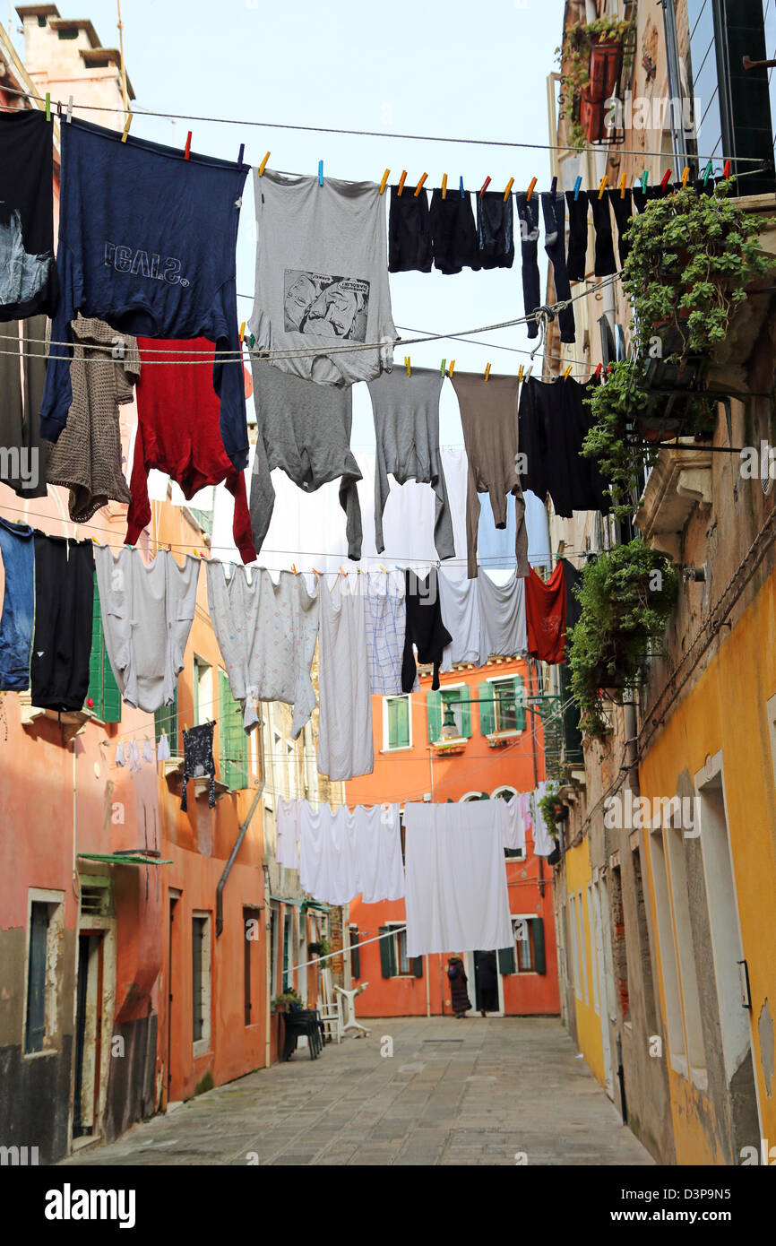 Drying clothes hanging out to dry on a washing line across a street on washday in Venice, Italy Stock Photo