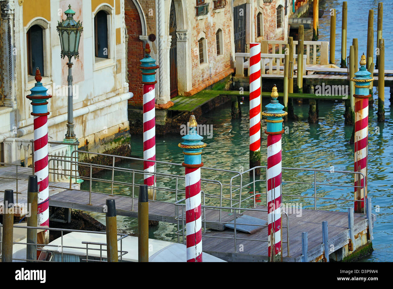 Red and white striped gondola mooring posts on the Grand Canal, in Venice, Italy Stock Photo