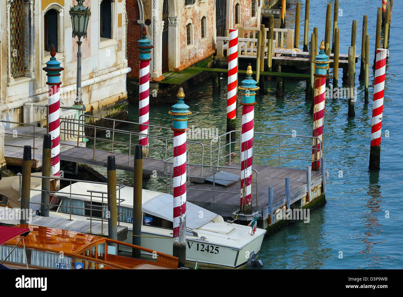 Red and white striped gondola mooring posts on the Grand Canal, in Venice, Italy Stock Photo