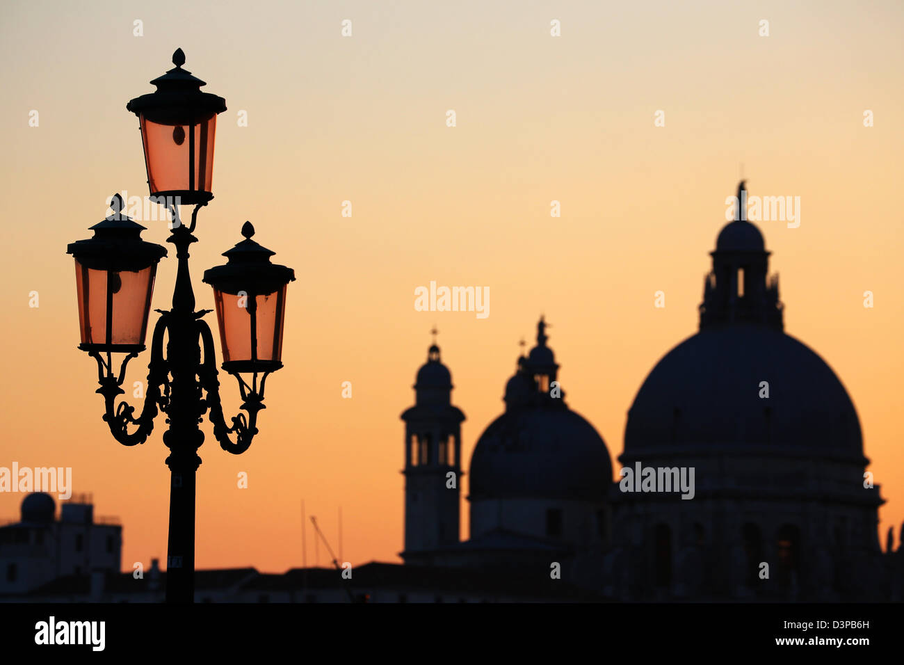 Silhouette of Santa Maria Della Salute and a lamp post at sunset in Venice, Italy Stock Photo