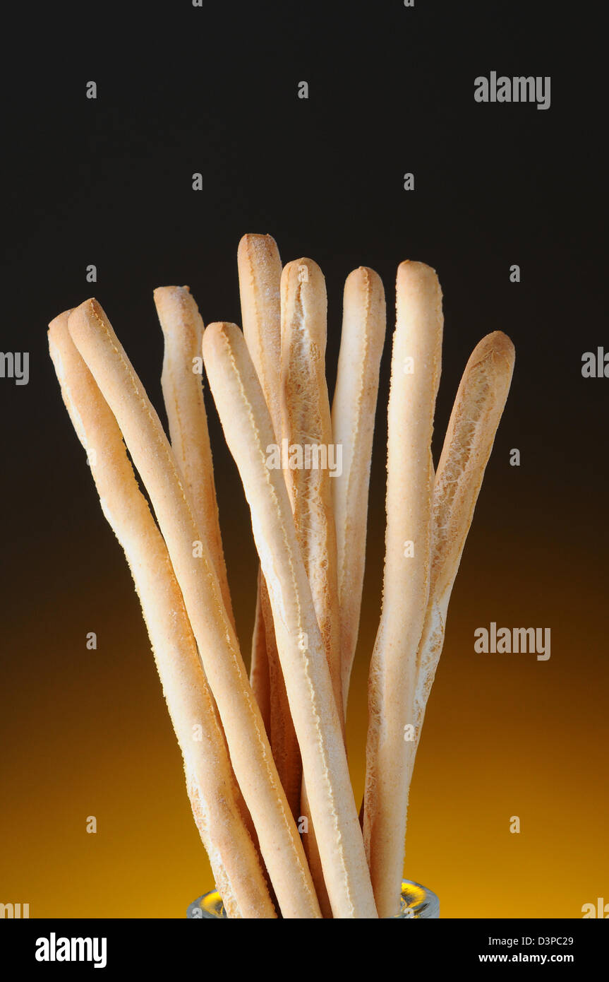 Closeup of bread sticks against a light to dark warm background. Vertical Format. Stock Photo