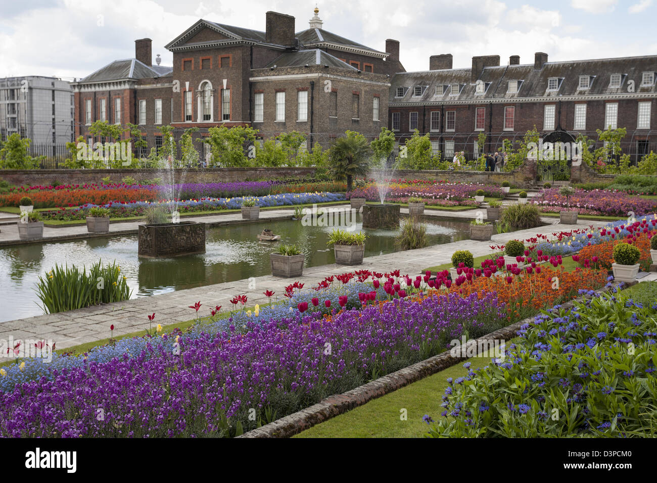 The colourful flower gardens at the rear of Kensington Palace. Multi coloured spring flowers decorate the pool at the palace Stock Photo