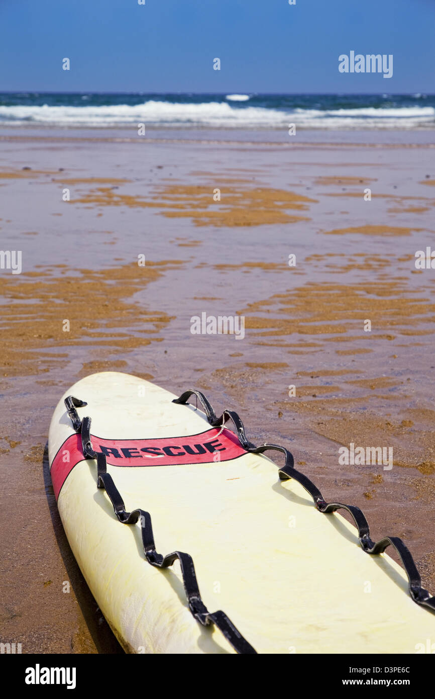 Lifeguard surfboard with the tittle rescue on the beach close to the shore Stock Photo
