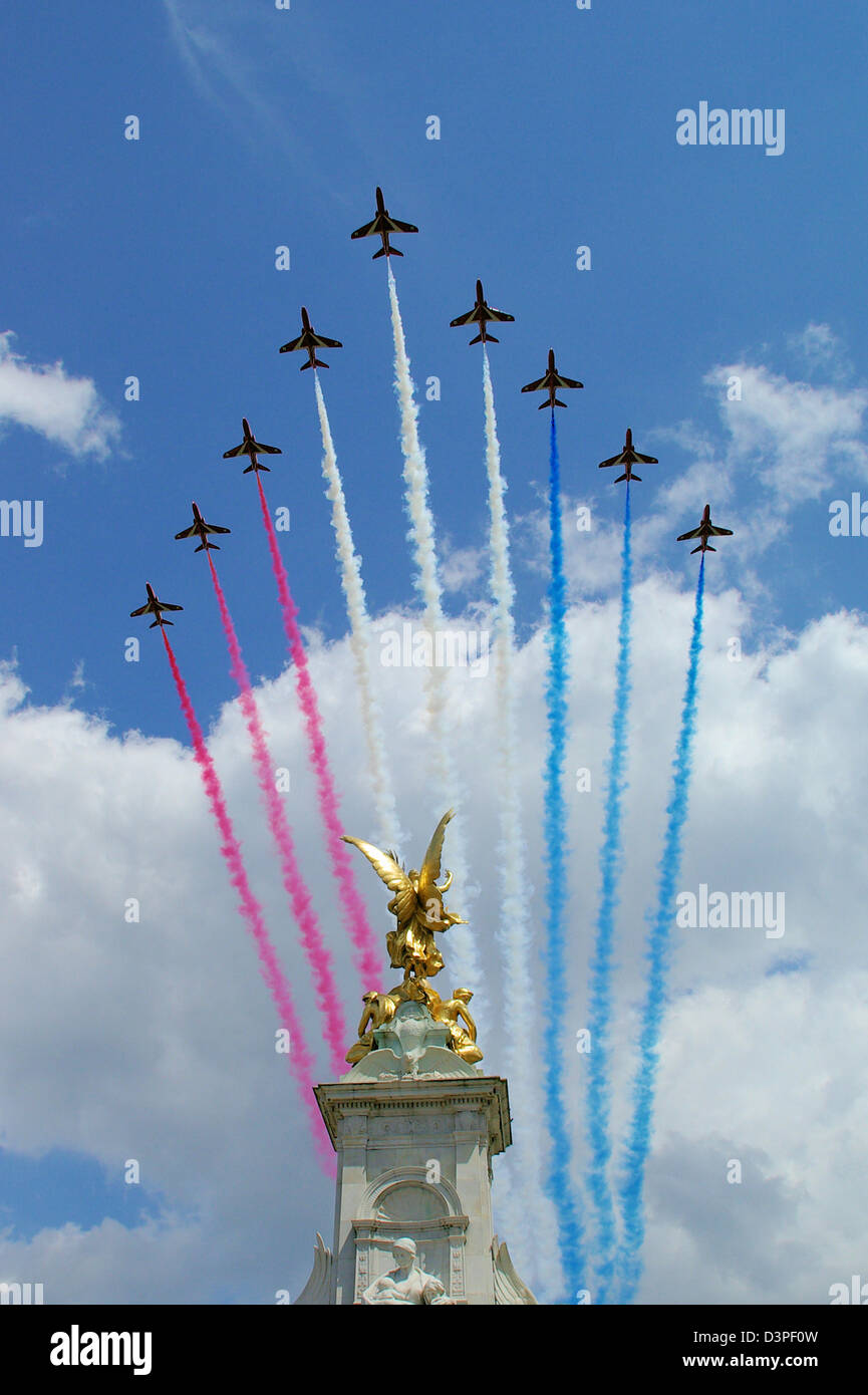 RAF Red Arrows passing down The Mall and over the Victoria Memorial whilst trailing red, white and blue smoke. Trooping the Colour, Queen's flypast Stock Photo