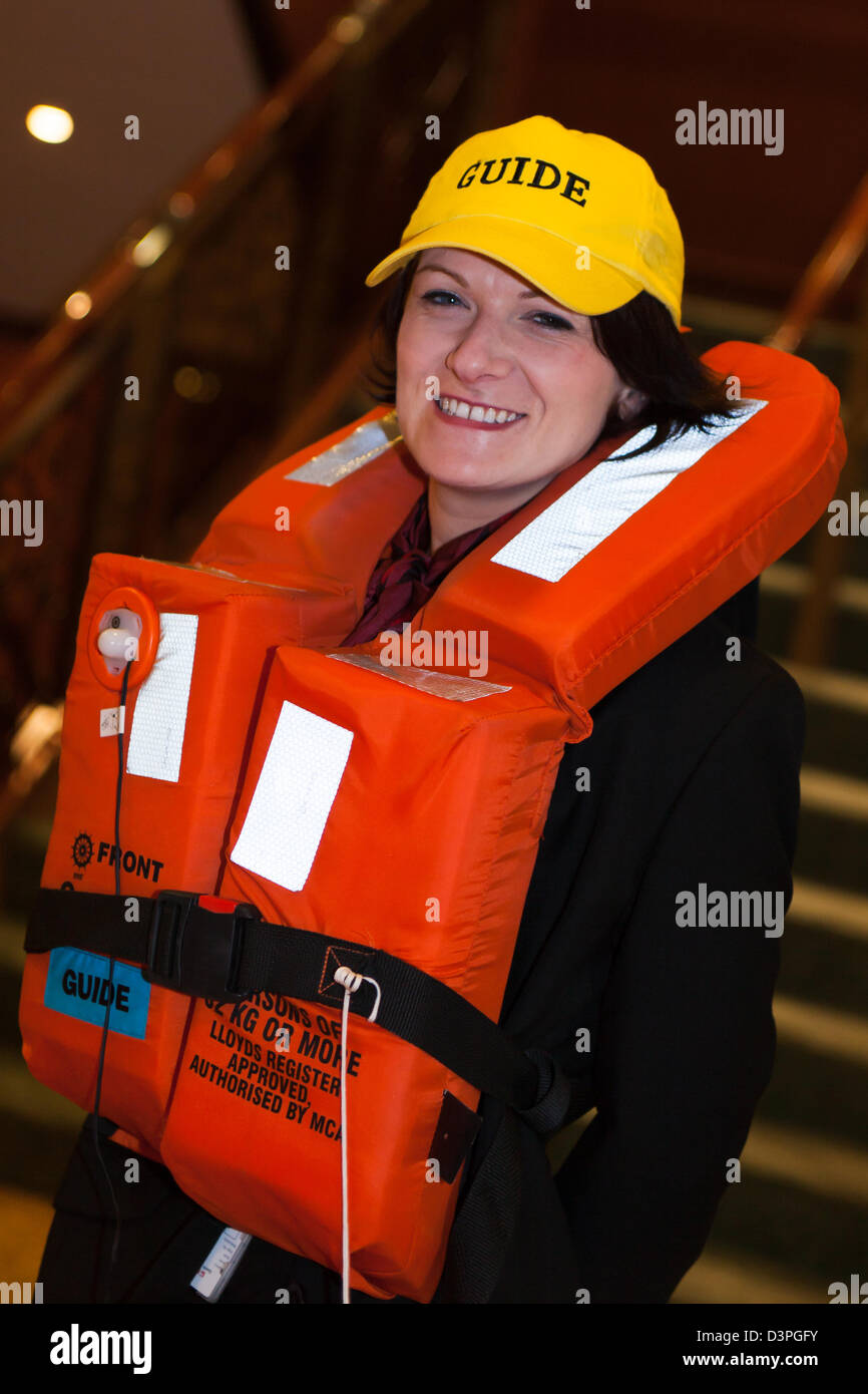 safety training. Ship's Crew guide on duty wearing lifejacket, during lifeboat drill for new crew & passengers at Cadiz Spain. Stock Photo