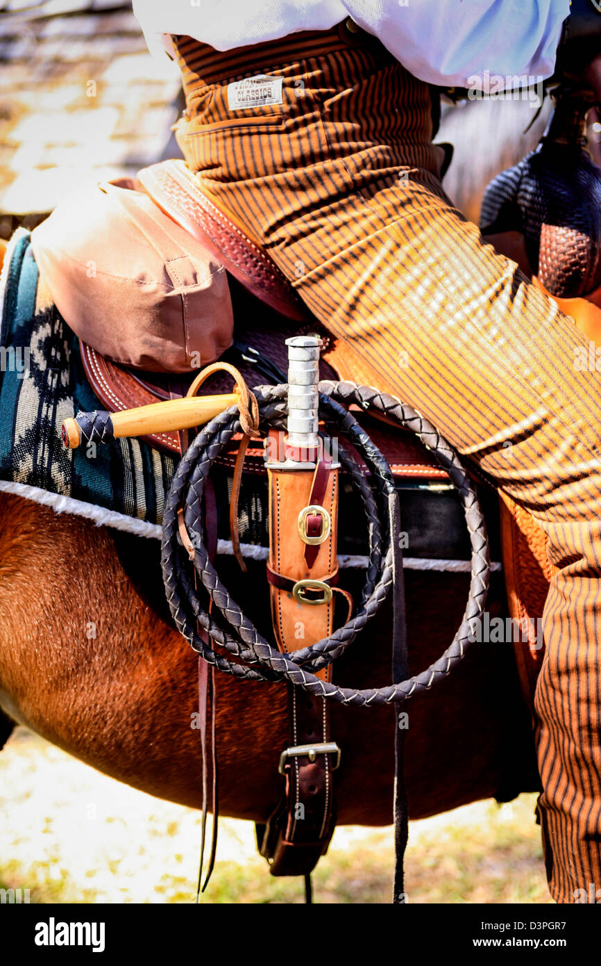 Close up of a Cowboy on horseback with his whip and bowie knife at an