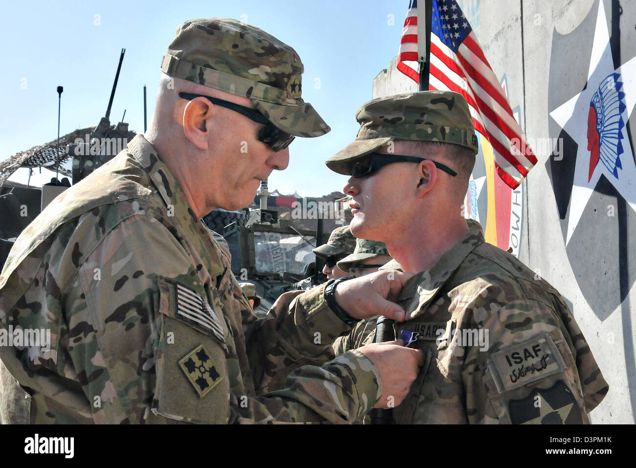 US Gen. Raymond Odierno, the Chief of Staff of the Army, pins Spc. Shawn Gravens with a Purple Heart February 22, 2013 at Forward Operating Base Masum Ghar, Afghanistan. Stock Photo