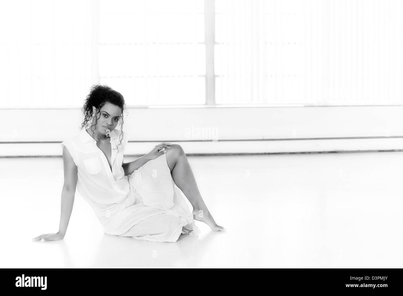 Young woman sitting on the floor in a studio Stock Photo - Alamy