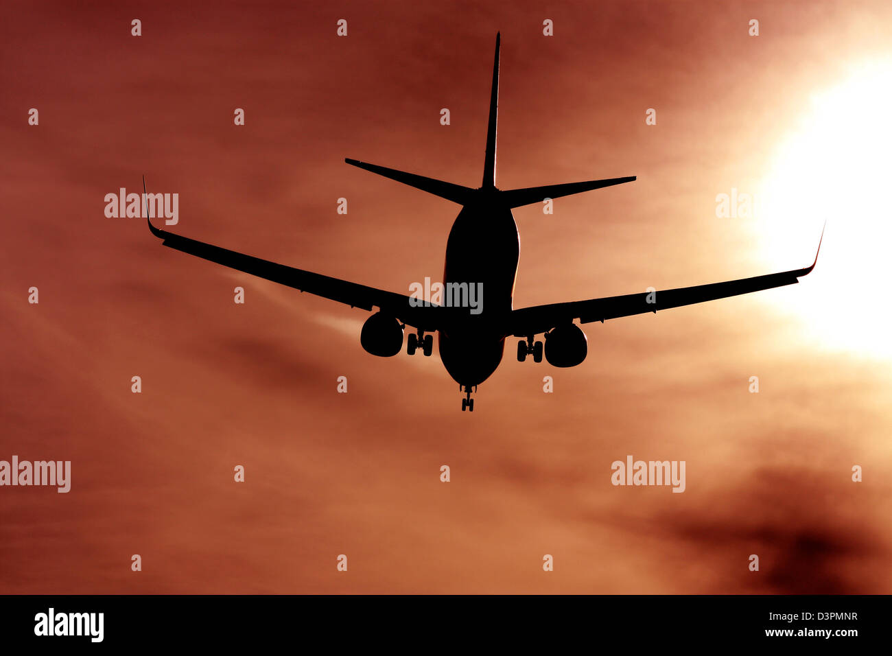 black silhouette of airplane agains the sun Stock Photo