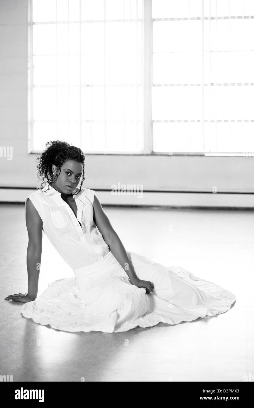 Young woman sitting on the floor in a studio Stock Photo - Alamy