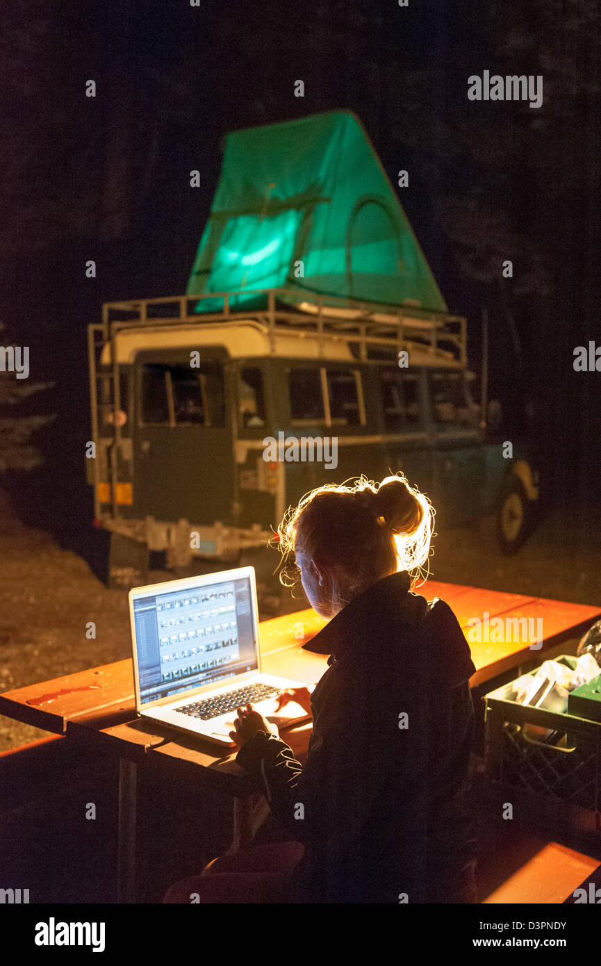 Woman working on laptop at campsite Sebago Lake Maine USA Stock Photo
