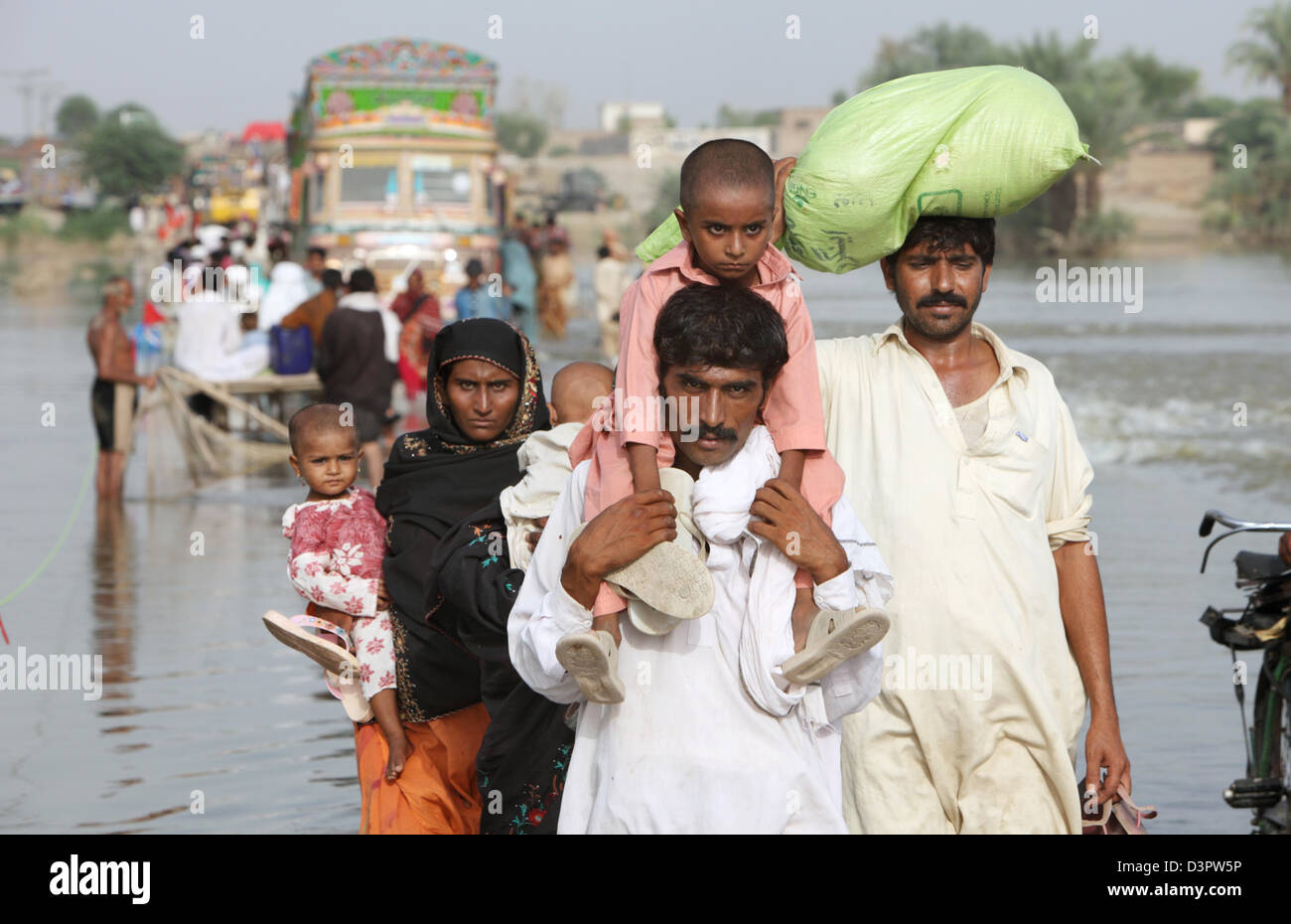 Muzaffargarh, Pakistan, People wade through flooded streets by Stock Photo