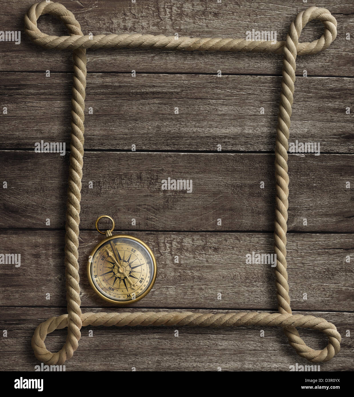 aged rope frame and old brass compass Stock Photo