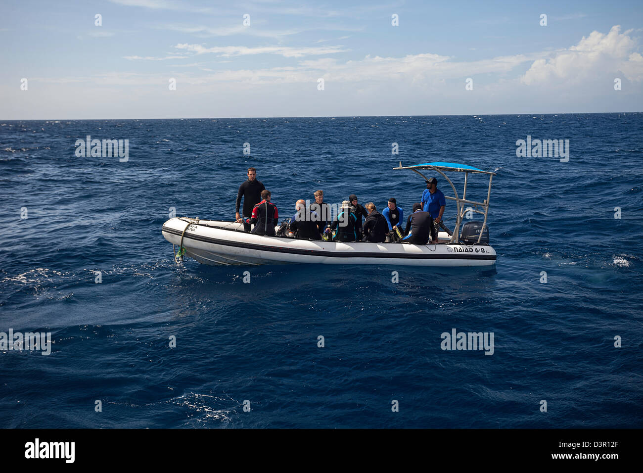Divers on a hard bottom inflatable leave the live-aboard vessel Nai'a on thier way to a dive site in Fiji. Stock Photo