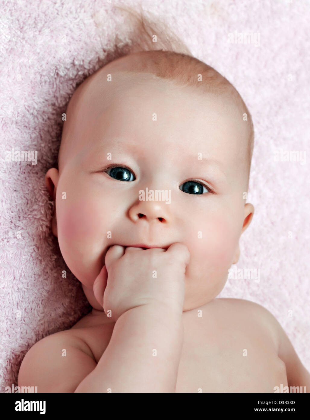 Newborn baby with fist in the mouth Stock Photo
